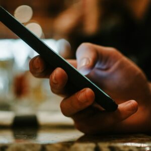 Close-up of a person using smartphone, highlighting tips on how to choose a best phone with strong battery life and performance in 2025.