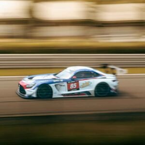 High-speed racing car number 85 on a race track in motion blur.